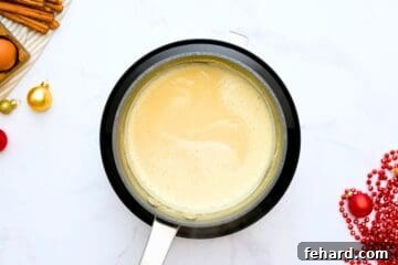 Thick and creamy homemade eggnog in small saucepan made with coconut milk and egg yolks.