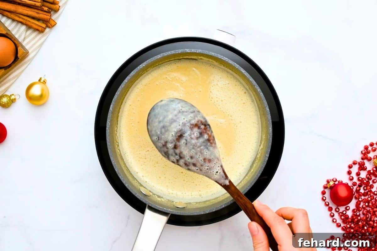 A wooden spoon coated with thick, non-dairy homemade eggnog, showing its rich and creamy consistency.