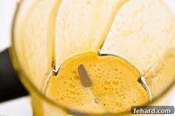Blender with egg yolks and maple syrup blended together until smooth.