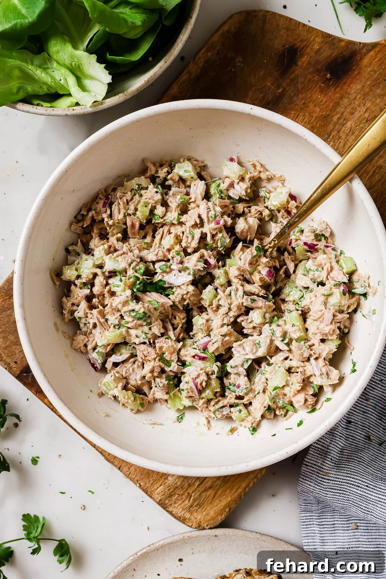 An overhead view of tuna salad in a large white bowl.