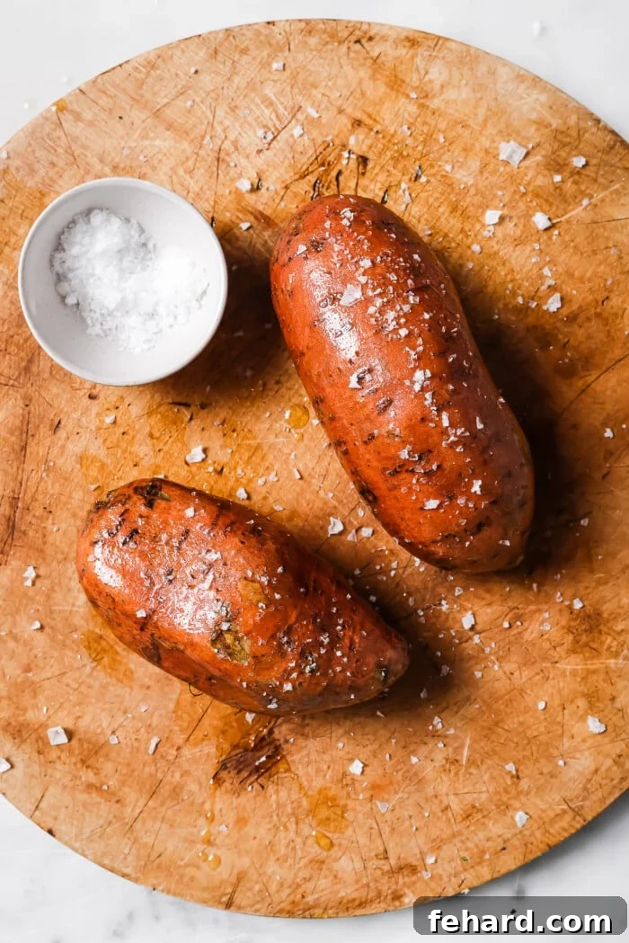 raw sweet potato with olive and salt on a countertop