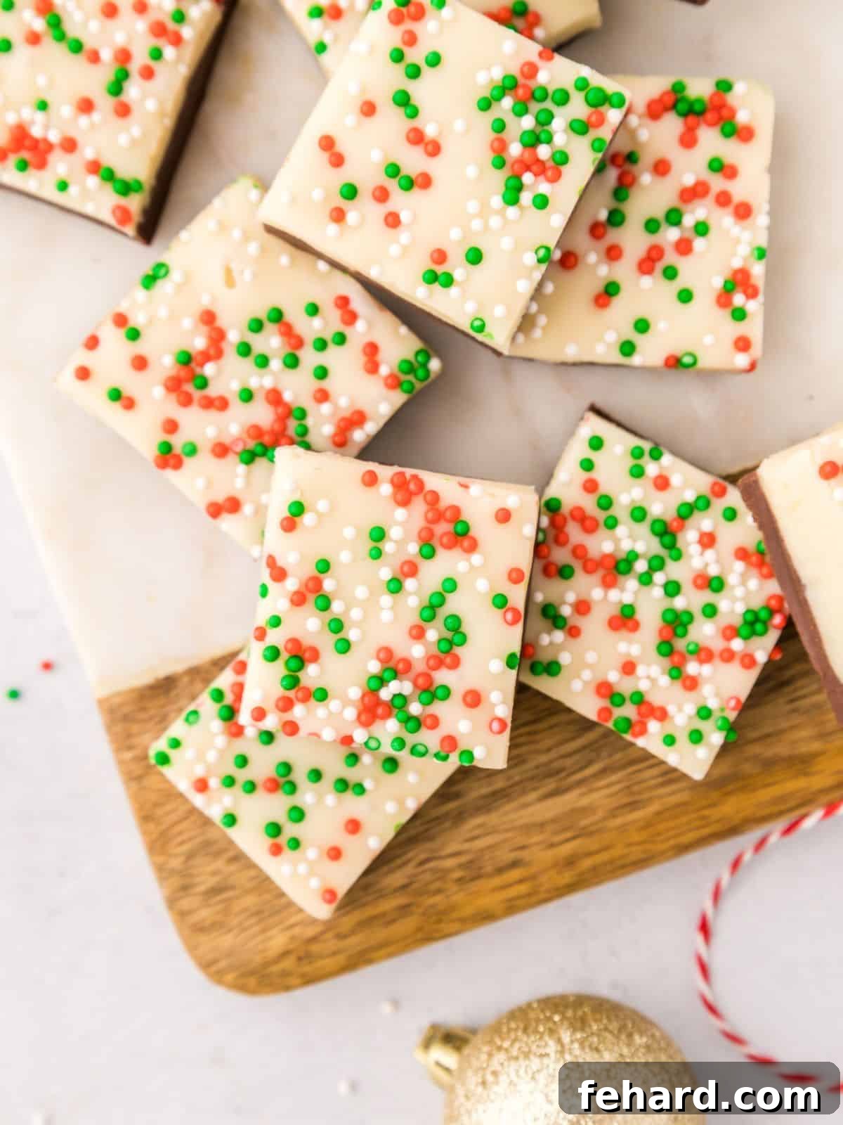 Top down view of pieces of Christmas Fudge with Christmas Nonpareils sprinkled on top of white chocolate layer.
