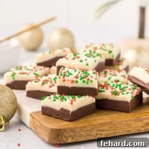 Layered fudge with Christmas sprinkles on cutting board.