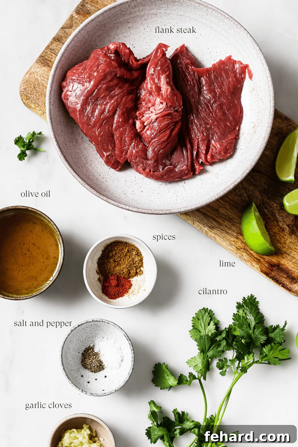 An overhead view of pre-measured ingredients for carne asada marinade on a white countertop.