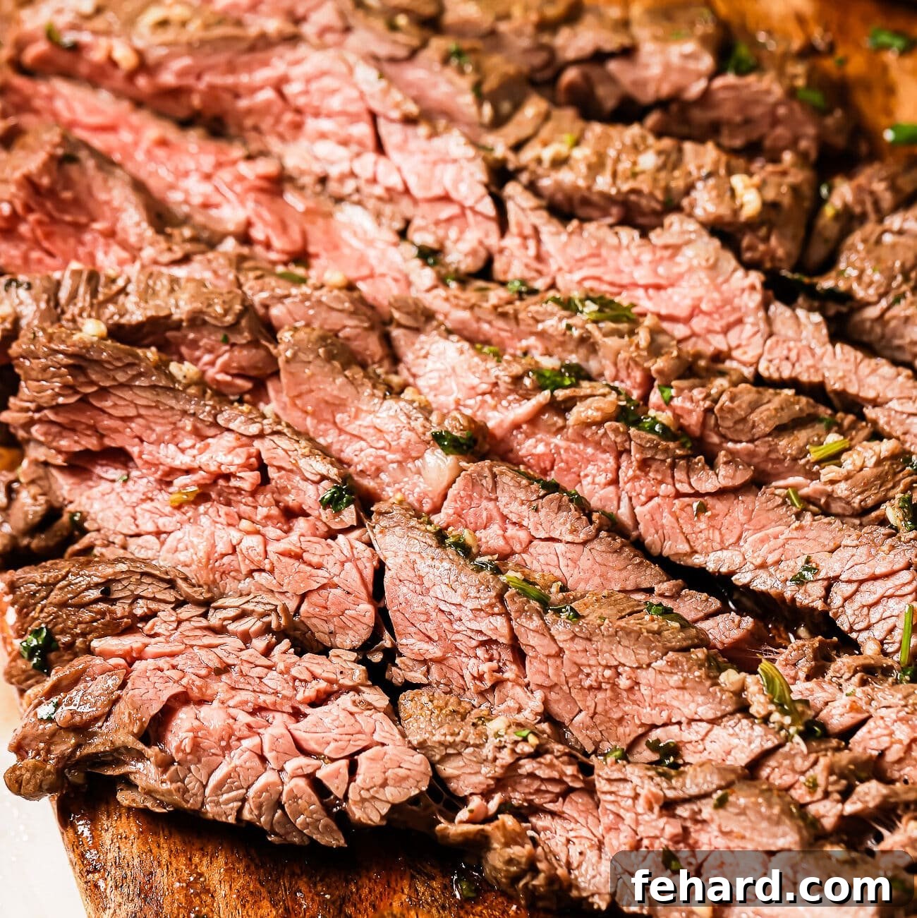 A close-up of thin-sliced carne asada on a cutting board. 