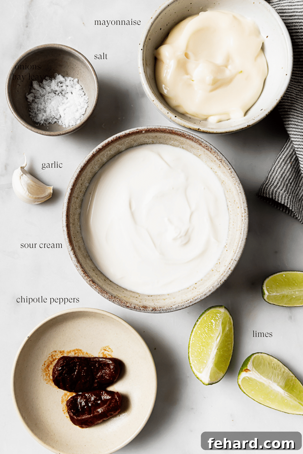 Homemade Smoky Chipotle Sauce 3 Pre-measured ingredients in small bowls on a white countertop.
