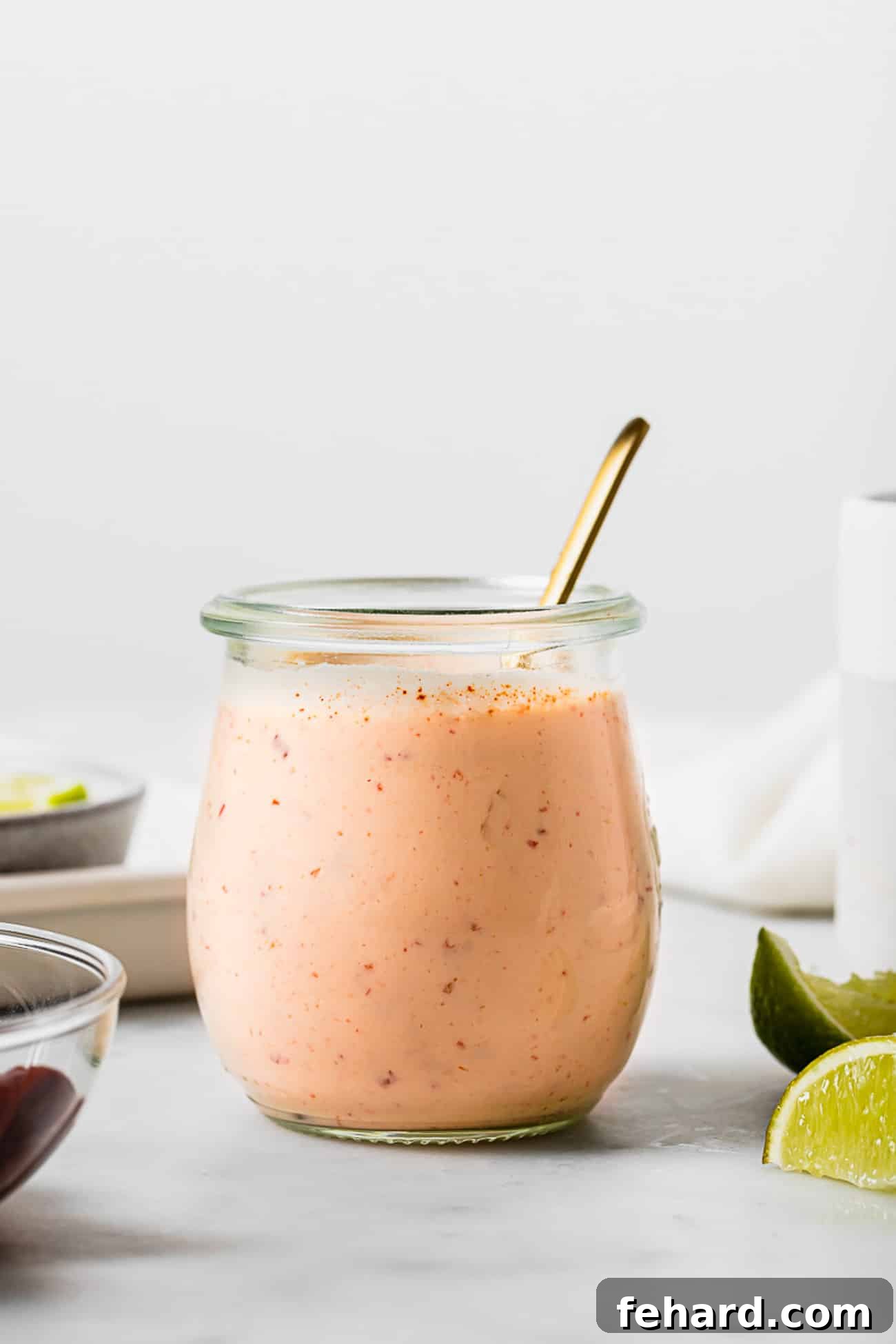Homemade Smoky Chipotle Sauce 6 A glass jar of chipotle sauce with a spoon in it.