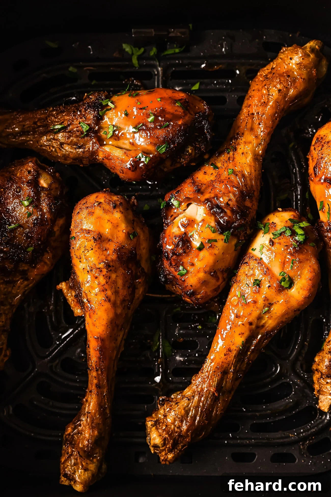 An overhead view of cooked chicken legs in the air fryer, perfectly golden and crispy.