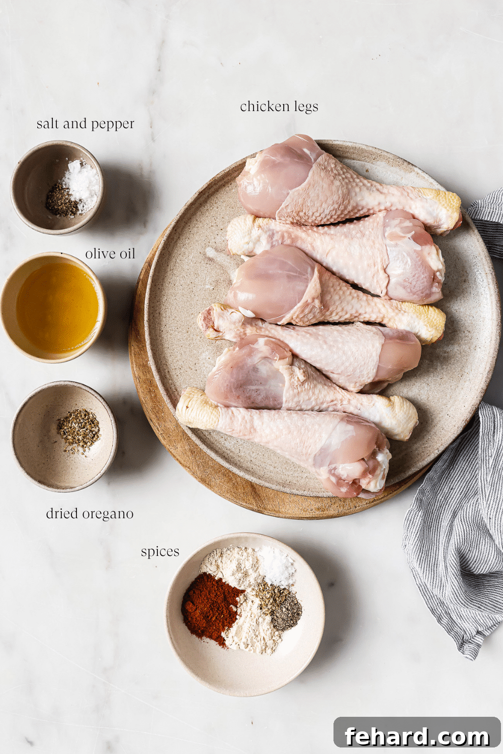 An overhead view of pre-measured ingredients in small bowls, ready for seasoning the chicken.