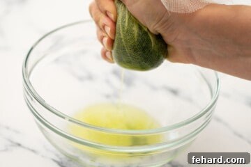 Frozen spinach in cheesecloth being squeezed over large bowl.