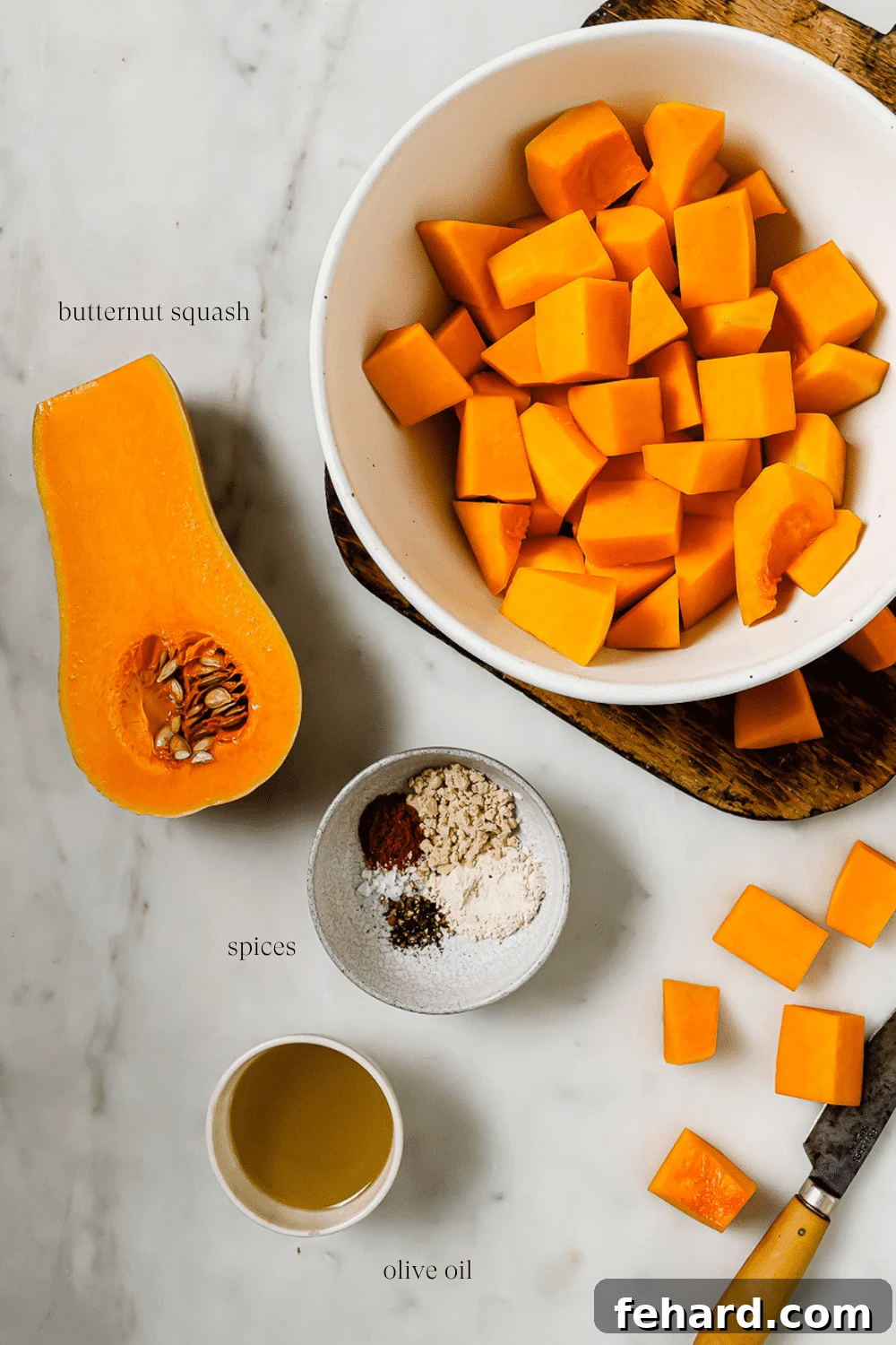Golden Air Fryer Butternut Squash 6 An overhead view of prepped ingredients and spices on a white countertop.