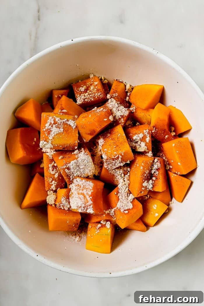 Golden Air Fryer Butternut Squash 7 An overhead view of butternut squash and seasonings in a bowl.