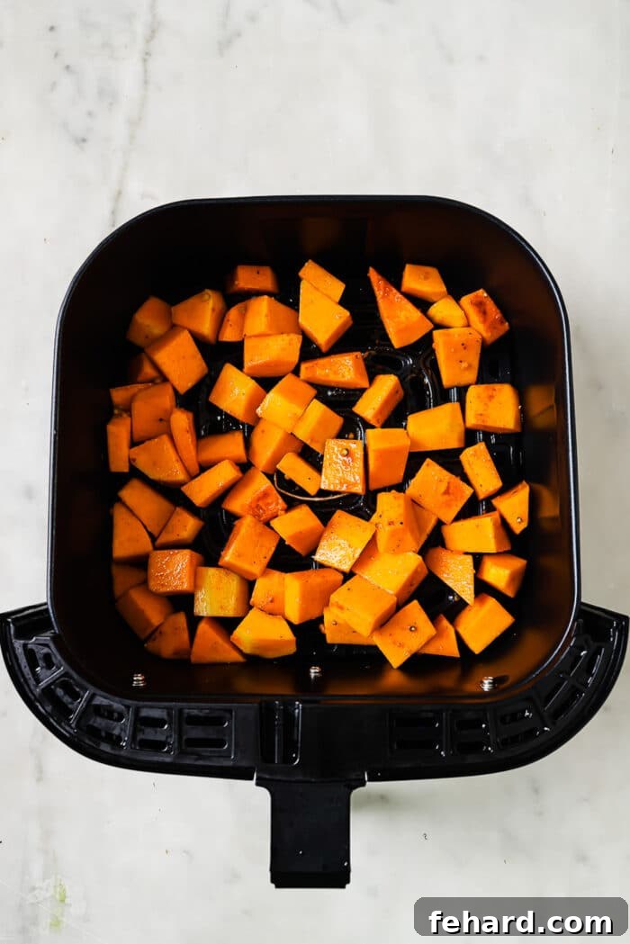 Golden Air Fryer Butternut Squash 9 An overhead view of butternut squash in an air fryer basket.