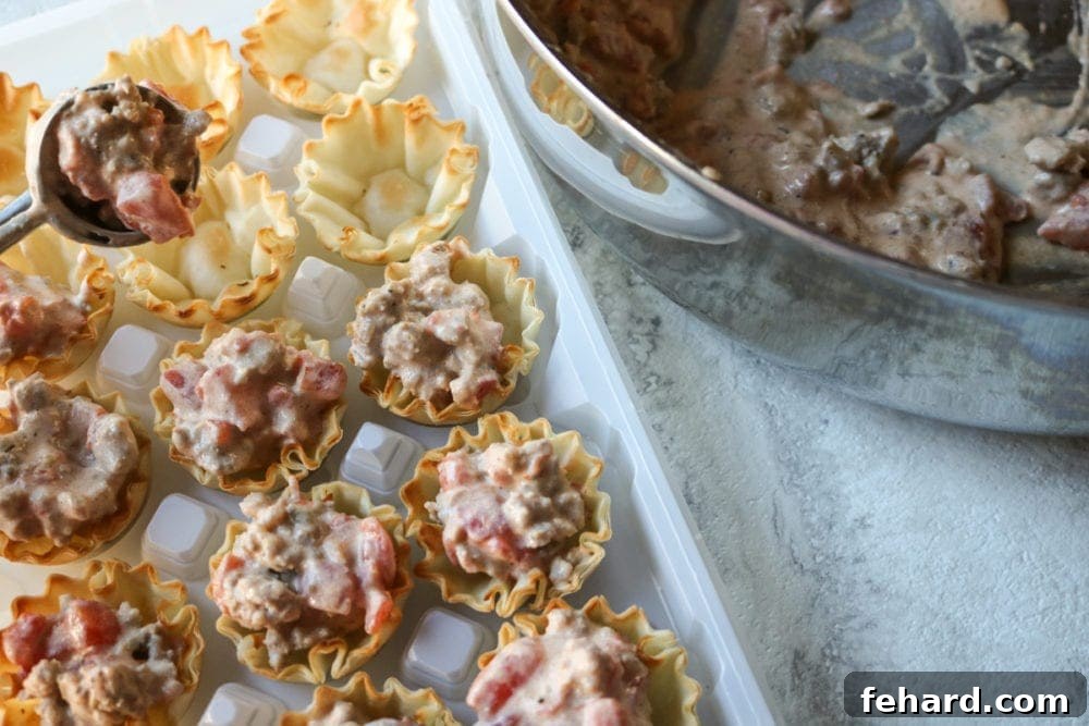 Portioning out creamy taco dip into phyllo cups
