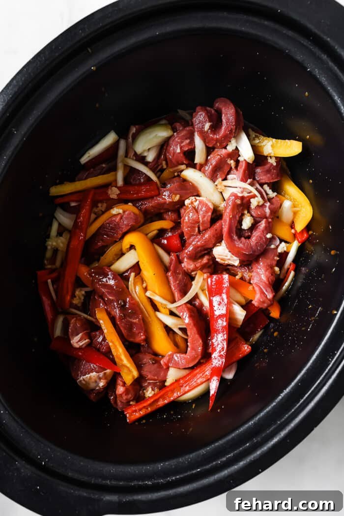 Melt-in-Your-Mouth Slow Cooker Pepper Steak 5 Bell peppers, onions, garlic, and sliced steak in the slow cooker.