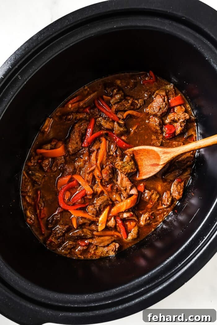 Melt-in-Your-Mouth Slow Cooker Pepper Steak 7 An overhead view of pepper steak in a slow cooker.