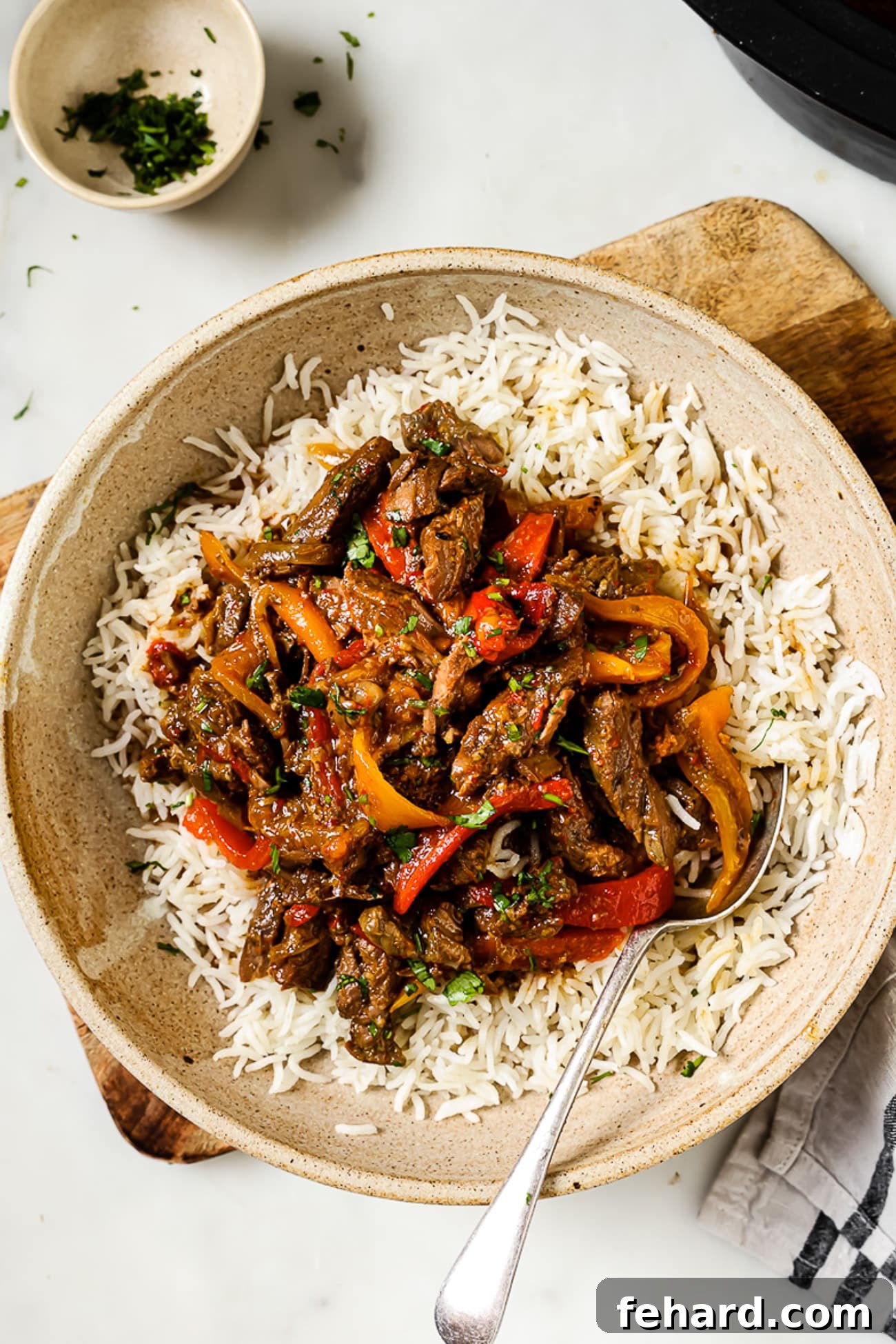 Melt-in-Your-Mouth Slow Cooker Pepper Steak 8 An overhead view of slow cooker pepper steak over a bed of rice.