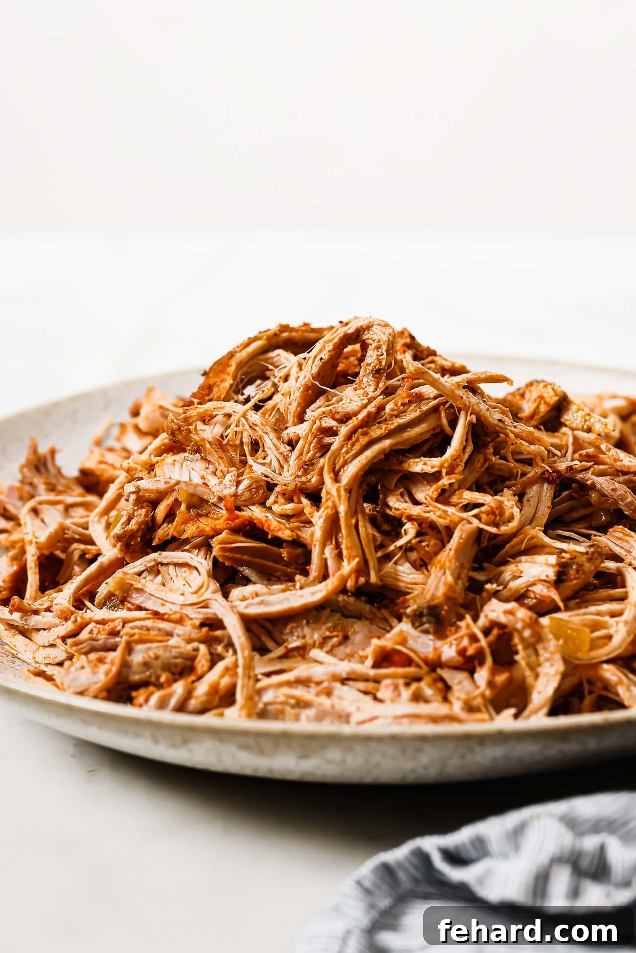 Melt-in-Your-Mouth Slow Cooker Pulled Pork 7 Slow cooker pulled pork piled on a serving plate.