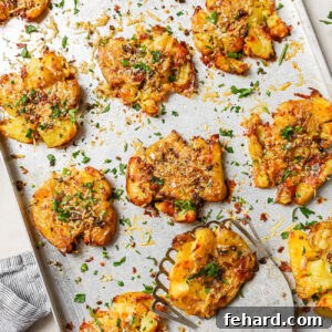 Crispy smashed potatoes on a baking sheet, ready to be served.