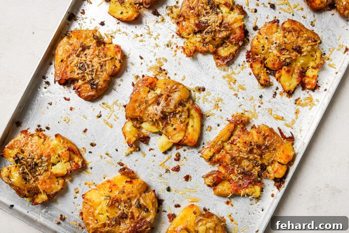 Crispy Smashed Potatoes 9 Golden roasted smashed potatoes on a baking sheet, cooked to crispy perfection, with a spatula poised to serve.