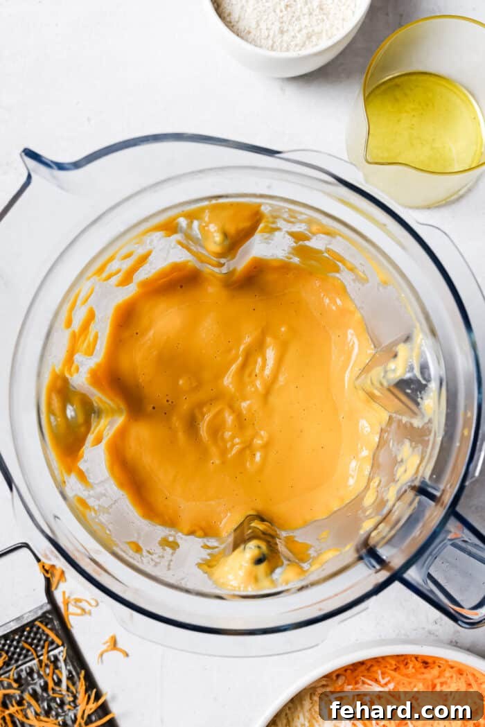 The blended butternut squash sauce in a blender, perfectly smooth and creamy, ready to be combined with cheese.