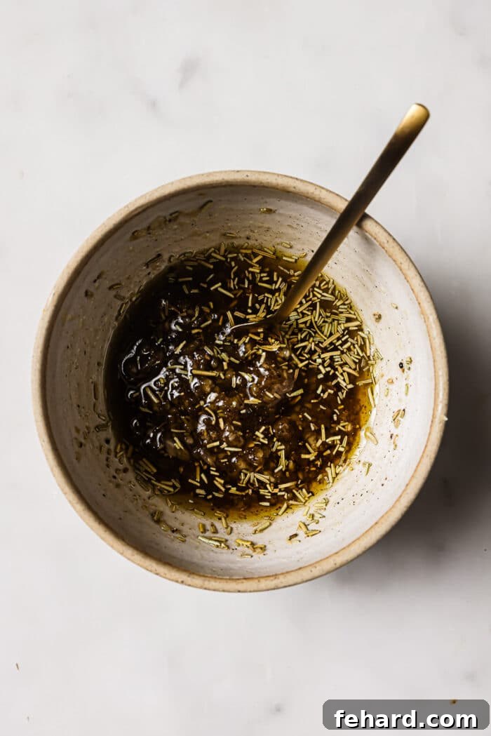 An overhead view of olive oil, seasonings, and brown sugar in a small bowl. 