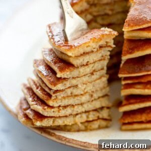 A forkful of fluffy gluten-free banana oatmeal pancakes, ready to be eaten.