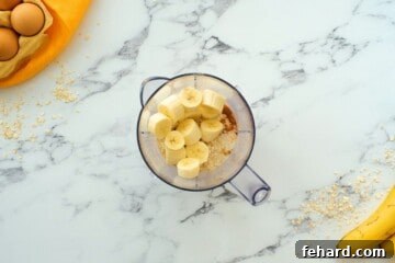 Ingredients for banana oatmeal pancakes layered in blender before blending.