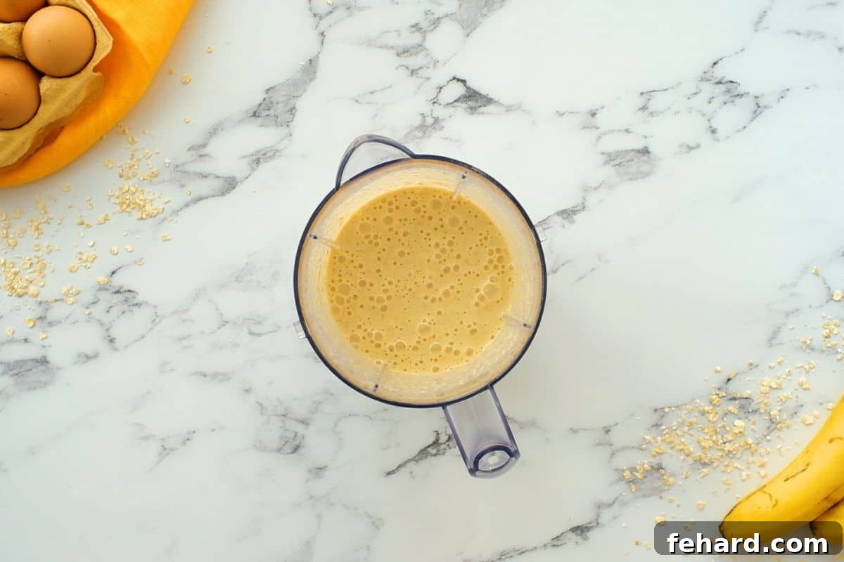 The perfectly smooth and creamy banana oatmeal pancake batter inside a blender after all ingredients have been thoroughly mixed.