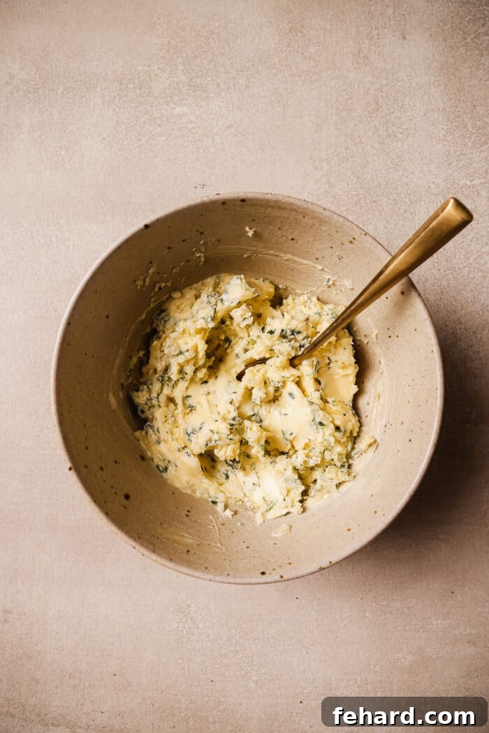 Golden Garlic Butter Tenderloin 4 Garlic butter in a bowl with a gold spoon in it.