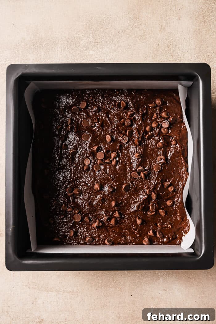 An overhead view of luscious brownie batter perfectly spread in an 8x8-inch square pan.