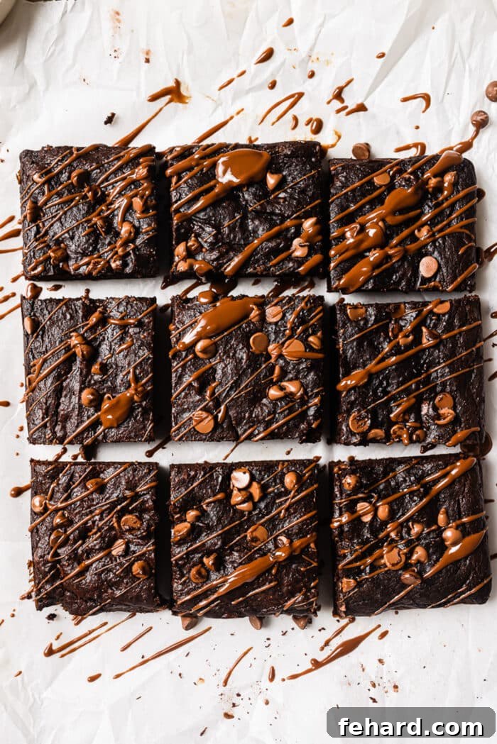 Healthy pumpkin brownies, cut into squares and elegantly drizzled with rich chocolate sauce.