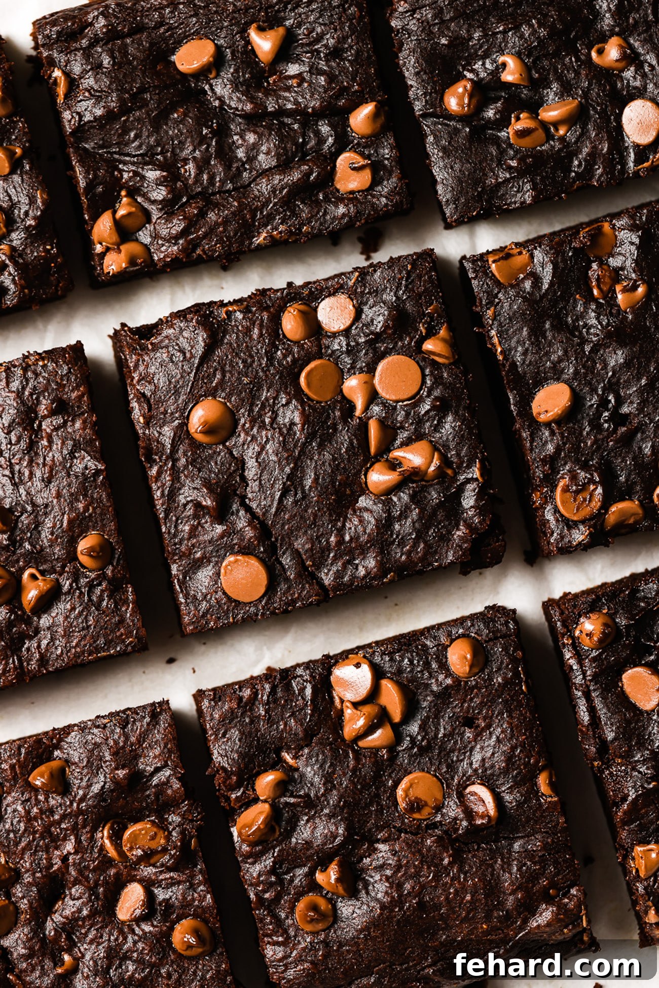A closeup of healthy pumpkin brownies cut into nine perfect squares, showcasing their rich, fudgy interior and chocolate chips.
