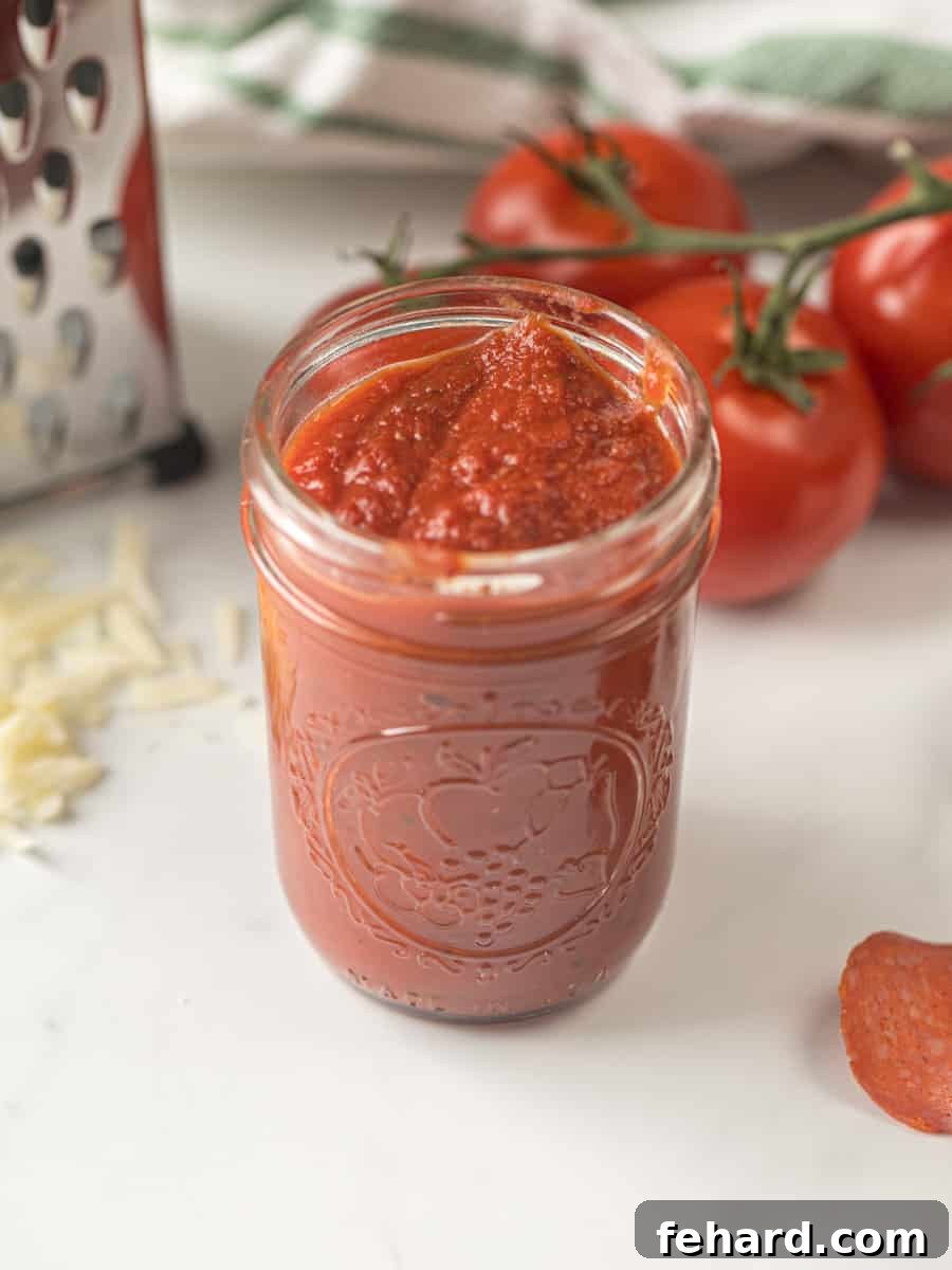 Homemade Pizza Sauce - Your Foundation for Perfect Pizza Jar of vibrant homemade pizza sauce, invitingly placed next to fresh pepperoni slices and blocks of mozzarella cheese, signaling a gourmet pizza experience.