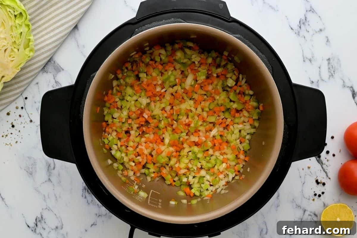 IP Cabbage Soup Recipe - Sauté Aromatics Sauteed Carrots, onions, and celery in instant pot, building a flavorful base for the soup.
