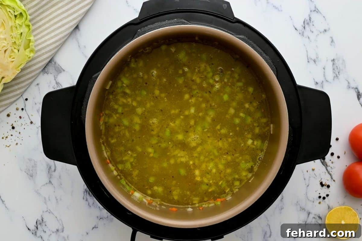 Cabbage Soup Instant Pot - Deglazing Broth being poured into the inner pot after sauteing veggies, with a wooden spoon ready to deglaze.