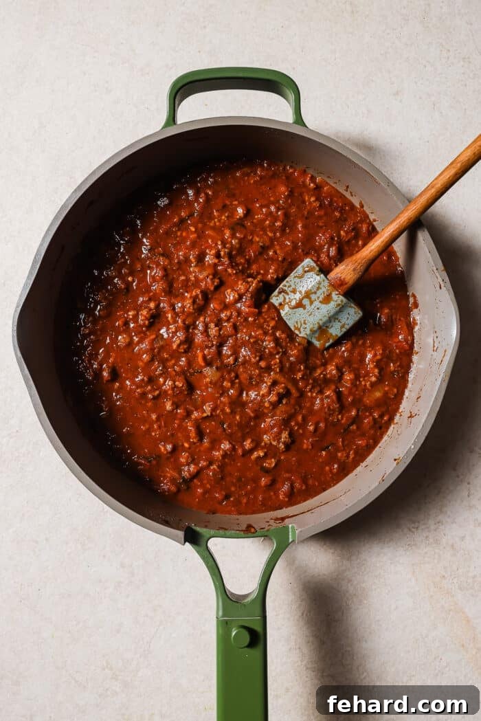 An overhead view of marinara meat sauce in a large skillet. 