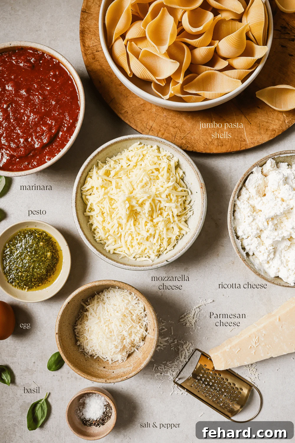 An overhead view of prepped ingredients in small bowls on a white countertop. 