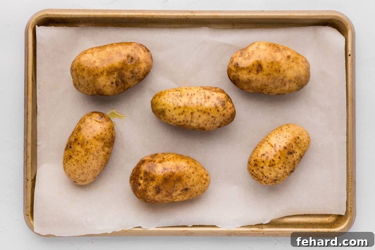 Best Potato Skin Recipe Russet Potatoes on baking sheet rubbed with olive oil and salt.