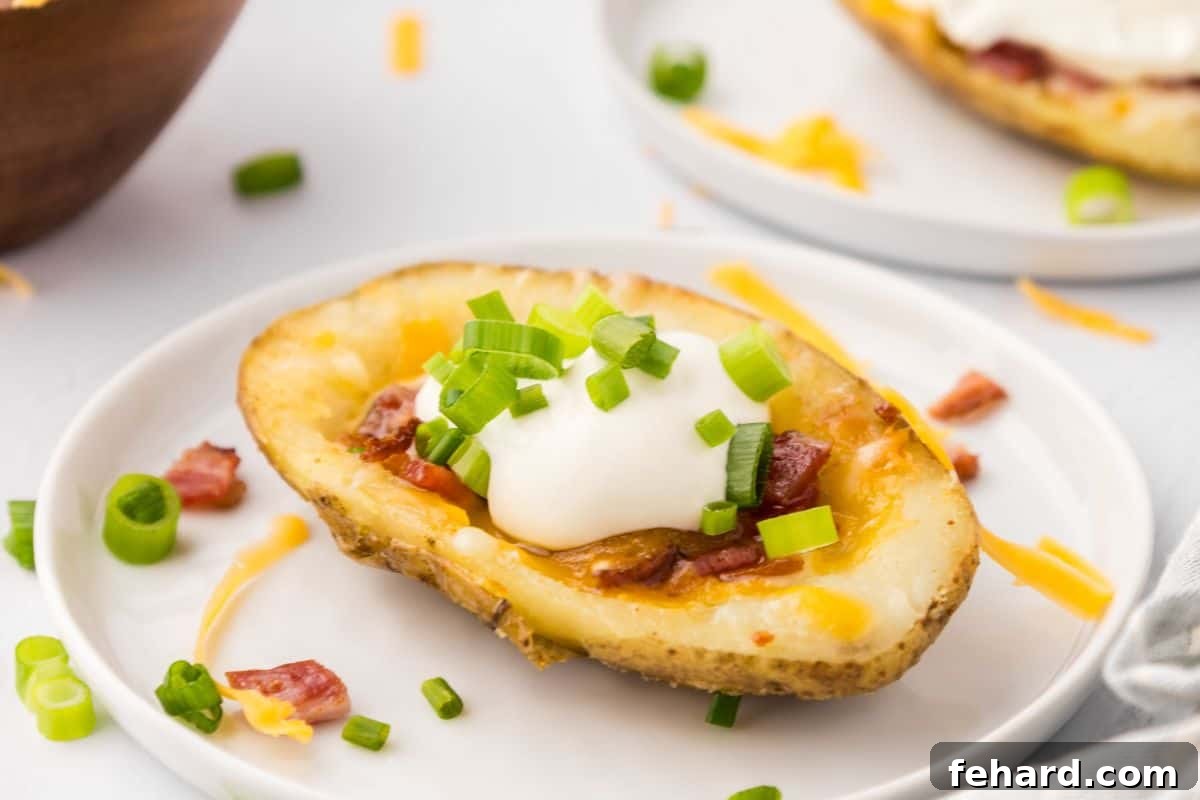 Loaded Potato Skin Recipe Crispy potato skin on white plate topped with sour cream, green onions, and bacon.