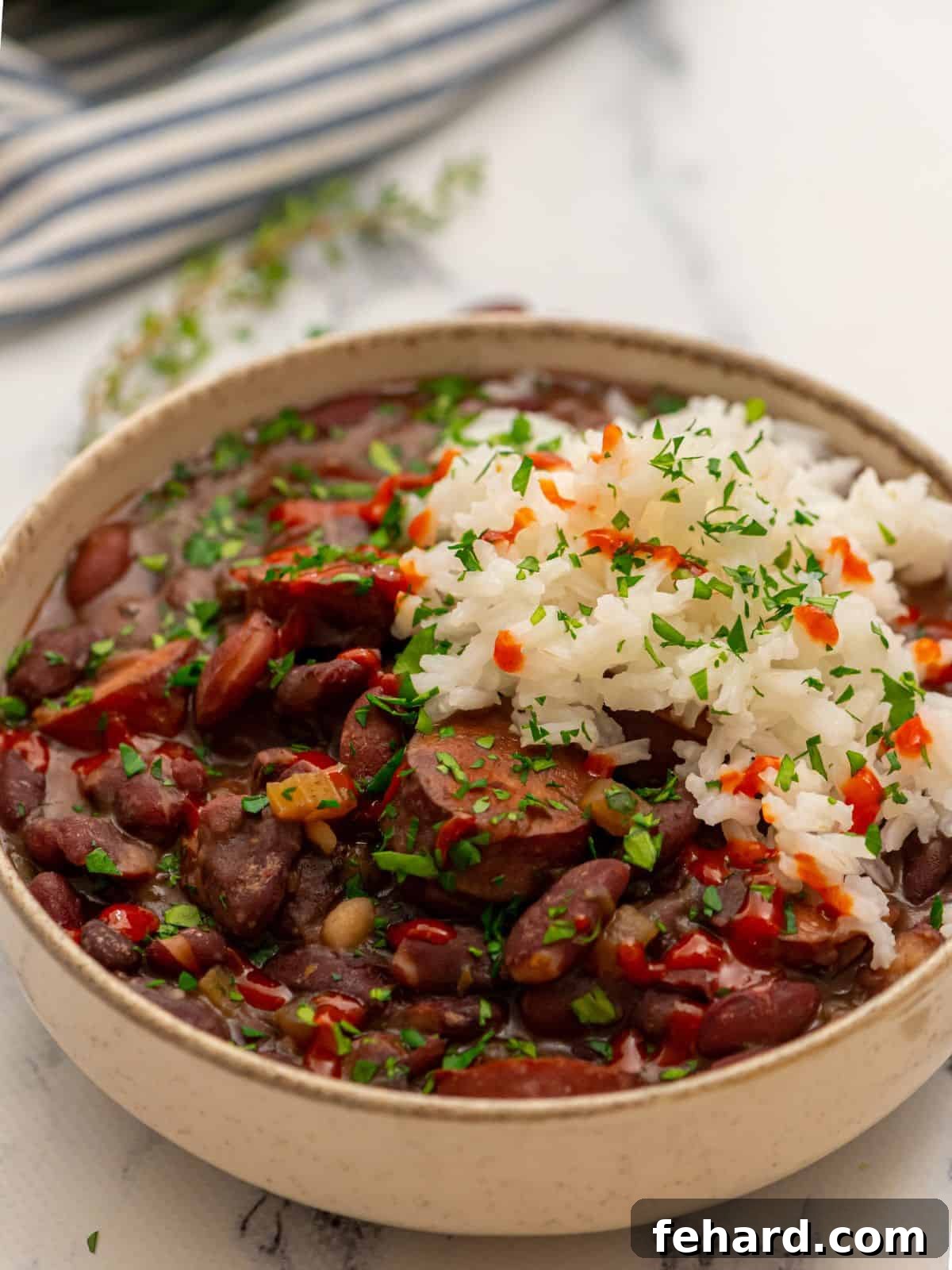 Instant Pot Red Beans and Rice beautifully plated in a cream-colored bowl, garnished with fresh parsley.