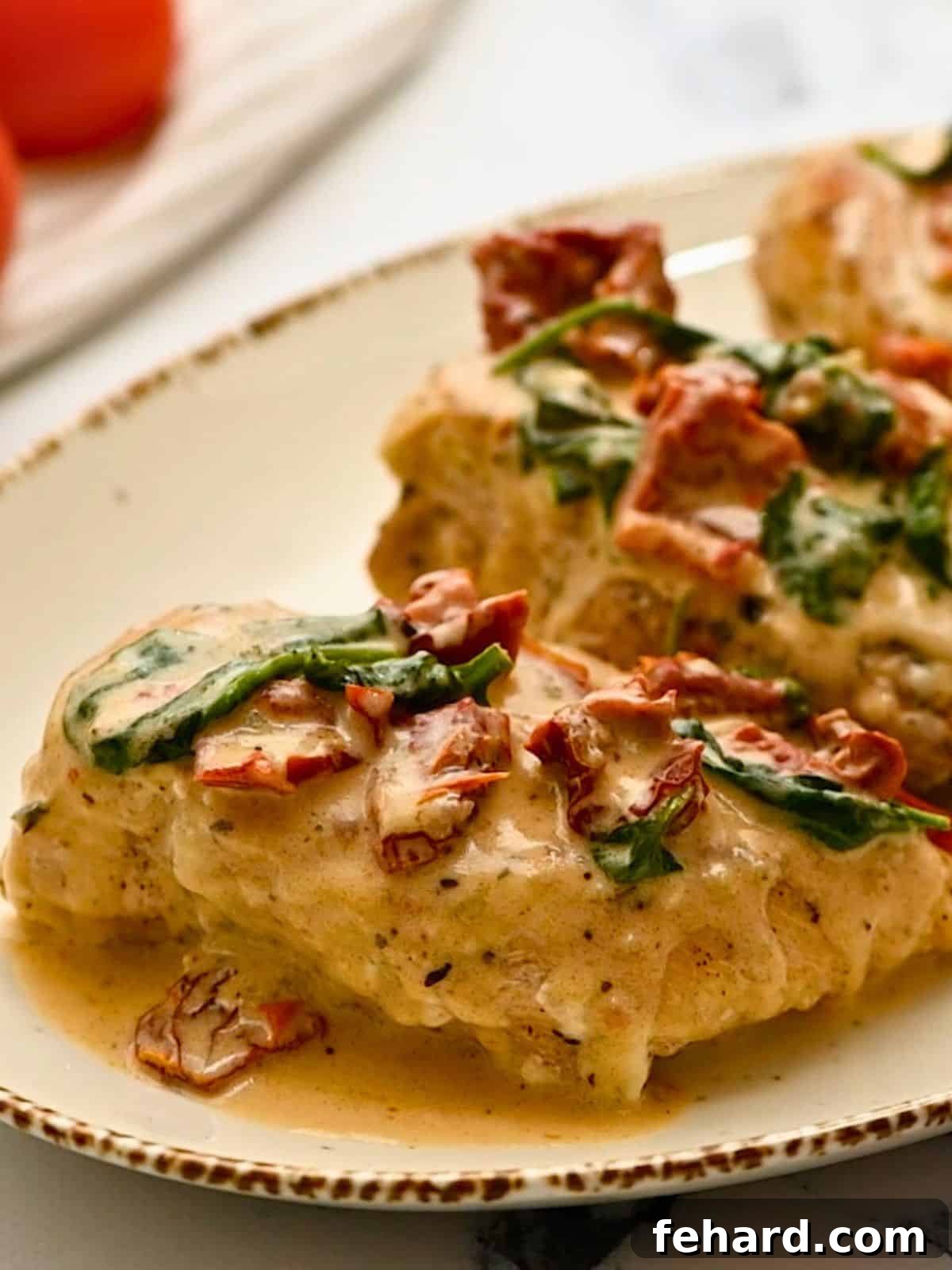 Instant Pot Marry Me Chicken Instant Pot chicken breasts on a platter, generously topped with creamy Parmesan sauce and vibrant sun-dried tomatoes.