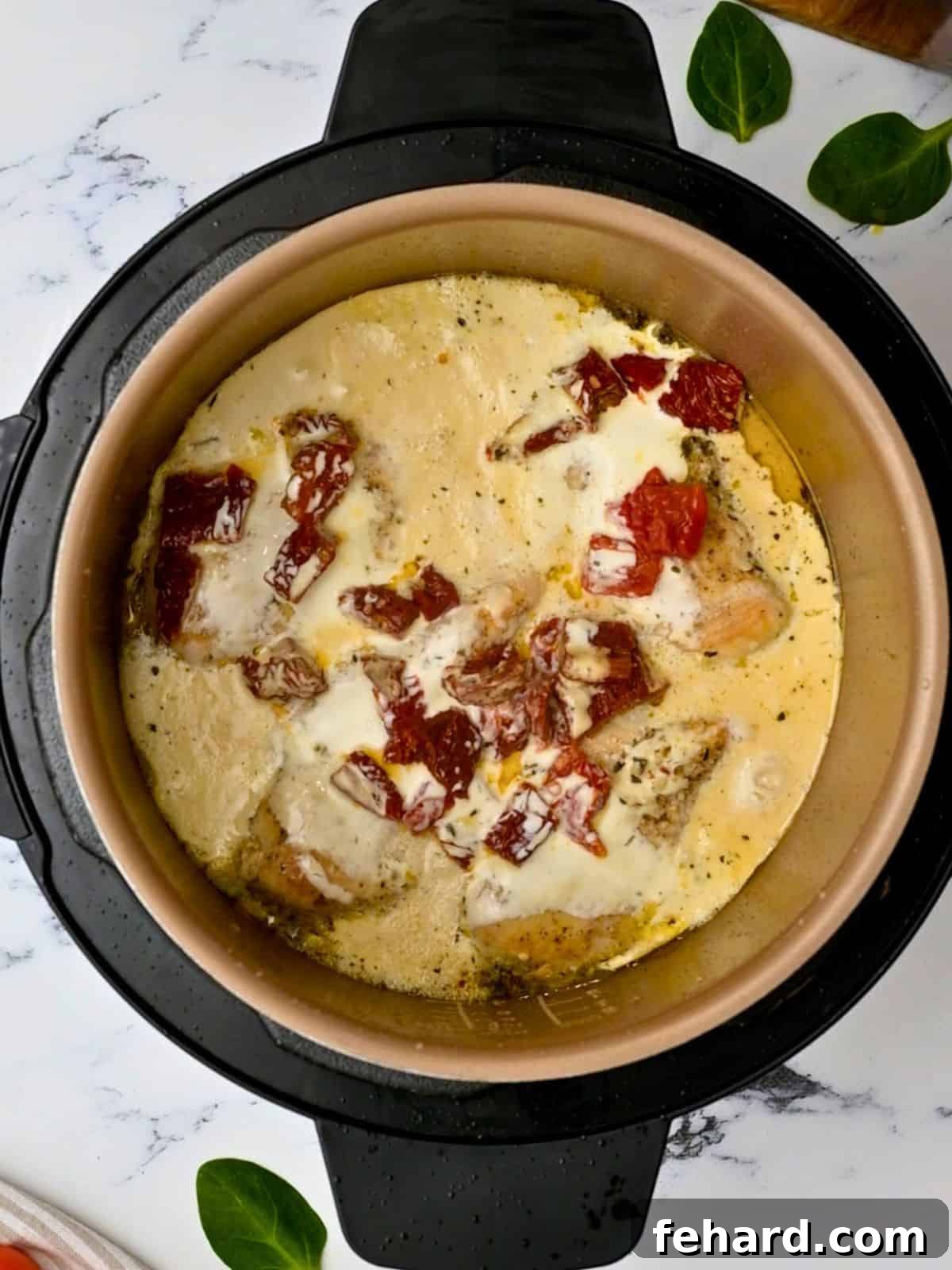 Instant Pot Chicken in Cream Instant Pot chicken breasts on platter topped with creamy parmesan sauce with sundried tomatoes.
