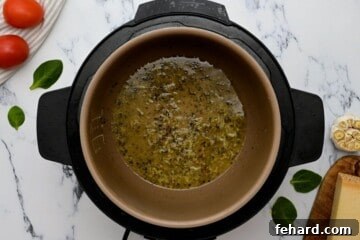 Instant Pot Chicken That Wins Hearts 2 Broth in inner pot with garlic, Italian seasoning, and red pepper flakes after sauteing.