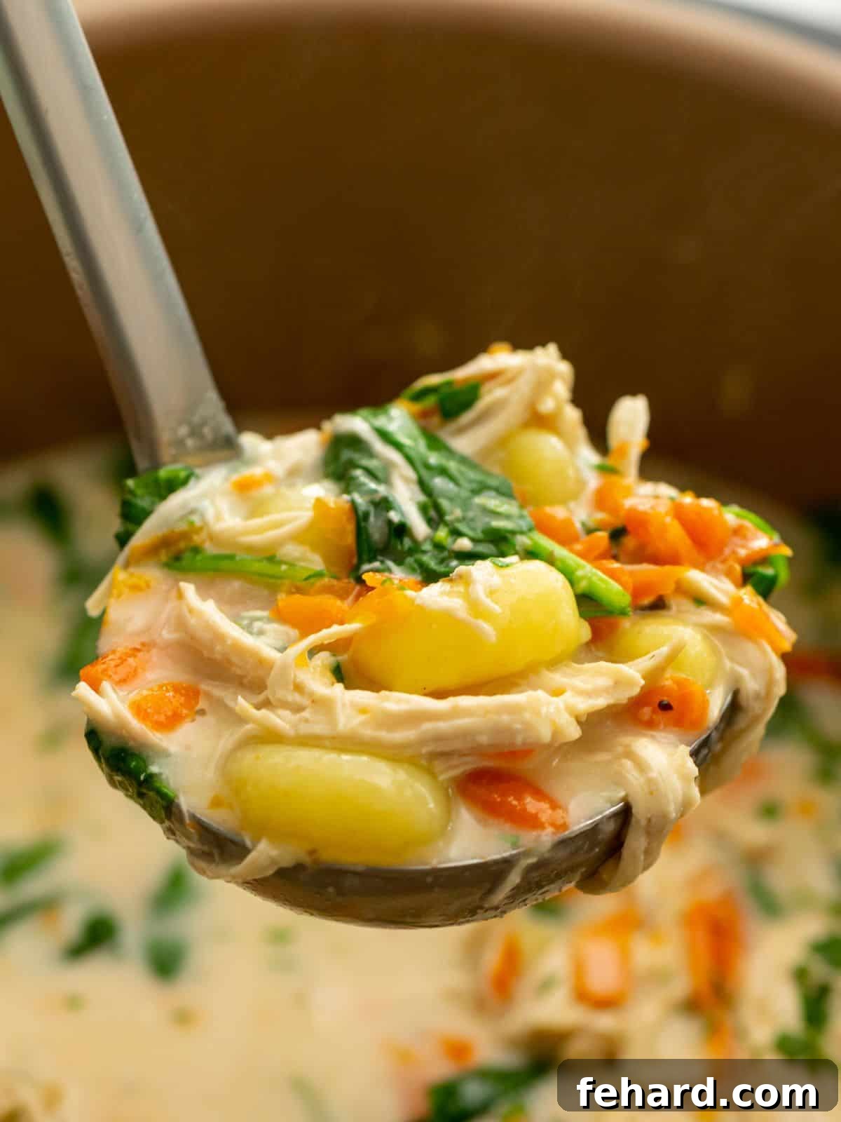 Ladle of creamy chicken gnocchi soup coming out of the Instant Pot, garnished with fresh parsley.