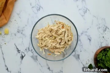 Shredded chicken after cooking it in the instant pot in large mixing bowl.