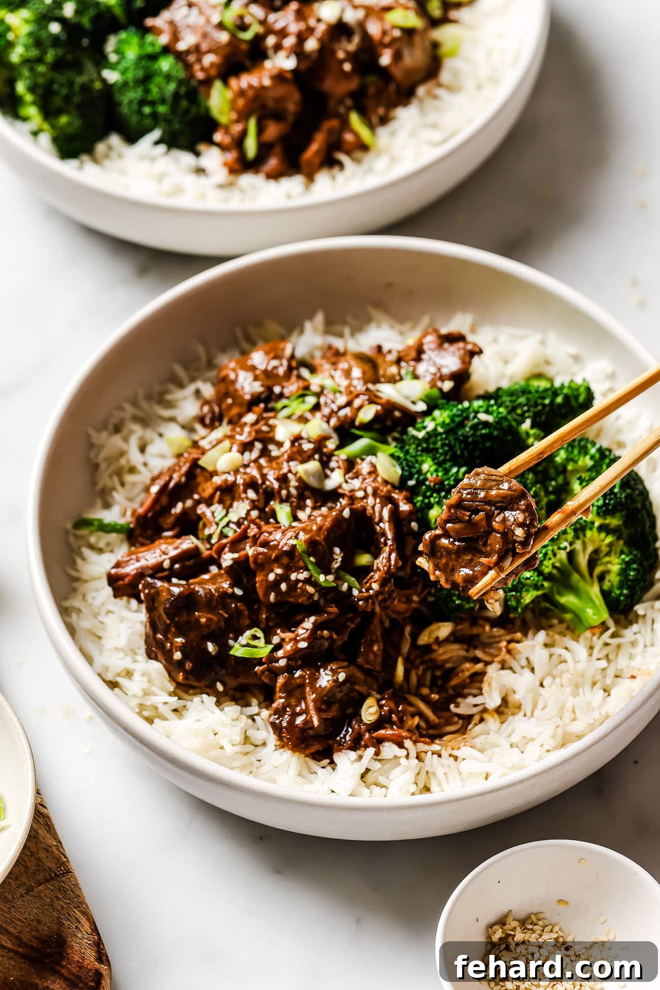 An overhead view of slow cooker Korean beef over rice with broccoli on the side. 