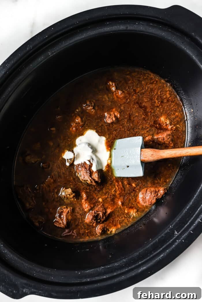 A cornstarch slurry is poured into the slow cooker.
