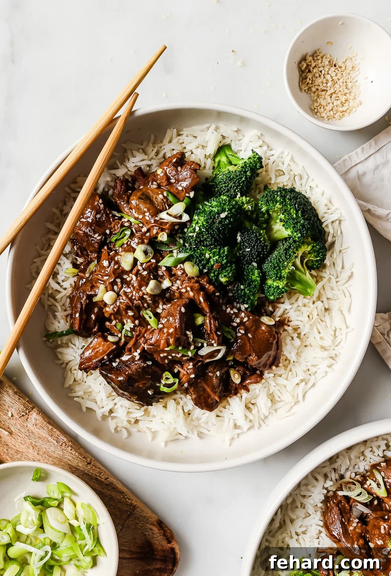 Slow cooker Korean beef over a bed of rice with a side of broccoli.