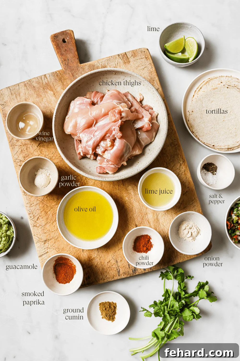 Flavor-Packed Homemade Chicken Tacos 3 Bowls of prepped ingredients on a wooden cutting board and white countertop.